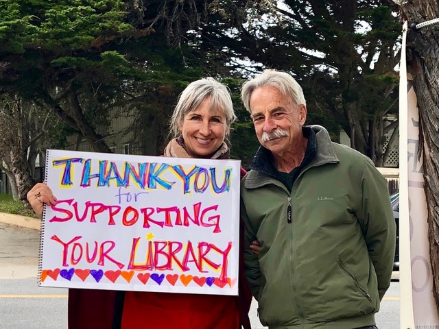 MPLF&F volunteers shown with "Thank you for supporting your Library" sign